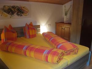 a bed with colorful pillows on top of it at Apart Pöll in Ried im Oberinntal