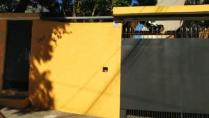 um edifício amarelo com um portão e uma cerca em Casa Paulista em São Paulo