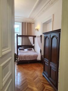 um quarto com uma cama e piso em madeira em Prestige Aparthotel Piotrkowska 82 - wyjątkowy widok na deptak em Lódź