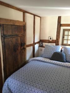 um quarto com uma cama e uma porta de madeira em Le Petit Cocon em Dambach-la-Ville