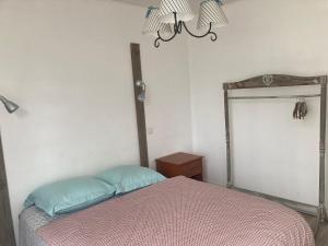 a bedroom with a bed and a chandelier at Appartement 2/3 personnes à 10 minutes de Contis plage (Saint Julien en Born) in Saint-Julien-en-Born