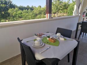 una mesa blanca con sillas y una mesa con comida. en Tenuta Turchi, en Otranto
