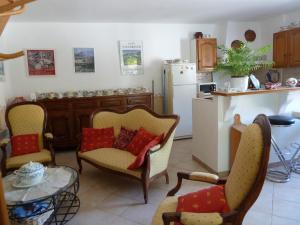 Saint-AndiolにあるLes Cigalesのキッチン(椅子2脚、テーブル、冷蔵庫付)