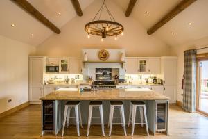 a kitchen with a large island with bar stools at Waterloo lodge in Lochinver