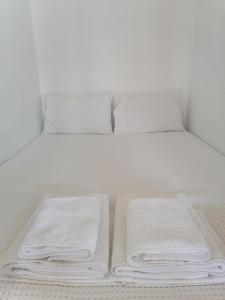 Olympos的住宿－Kalliopis Studio，一张白色的床,上面有3条折叠毛巾