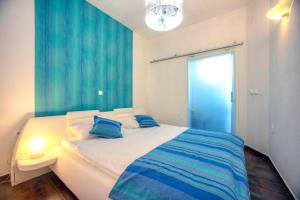 a bedroom with a large bed with blue curtains at Villa Barbara in Skradin