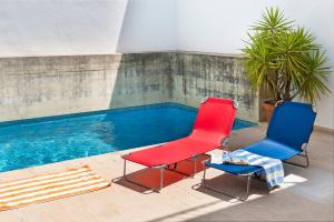 2 sillas sentadas junto a una piscina en AlohaMundi Triana, en Sevilla