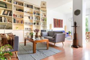 una sala de estar con una gran estantería para libros. en AlohaMundi Triana, en Sevilla