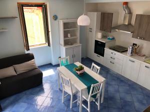 a living room with a table and chairs and a kitchen at NEL BLU in Cetara +18 photos
