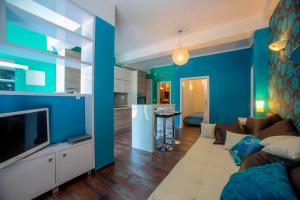 a blue living room with a couch and a tv at Villa Barbara in Skradin