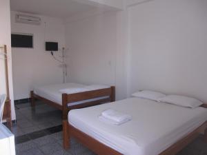 a small room with two beds and a tv at Hotel Mecejana in Boa Vista