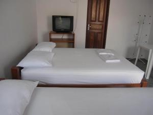 dwa łóżka w małym pokoju z telewizorem w obiekcie Hotel Mecejana w mieście Boa Vista