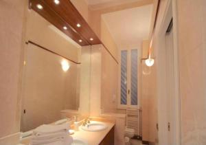 bagno bianco con lavandino e specchio di Trevi Nice Holiday - Luxury Apartment a Roma