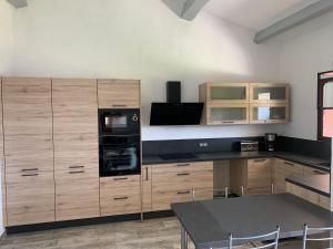 una cocina con armarios de madera y una mesa con sillas. en Playa del Oro, en Favone