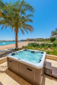 un bain à remous sur une terrasse avec un palmier dans l'établissement Golden Apartments El Gouna, à Hurghada