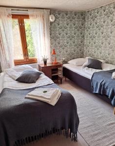 a bedroom with two beds and a window at Solvillan in Korppoo