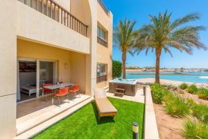 un patio avec une table et des chaises à côté d'un bâtiment dans l'établissement Golden Apartments El Gouna, à Hurghada