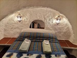 a bedroom with a bed in a stone wall at Casa Cueva Guadix in Guadix