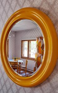 a large orange mirror in a room with a table at Solvillan in Korppoo