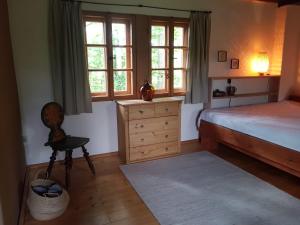 a bedroom with a bed and a dresser and windows at Berghütte Fürstenwalde in Fürstenwalde