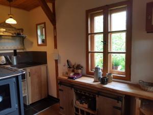 a kitchen with a wooden counter top and two windows at Berghütte Fürstenwalde in Fürstenwalde