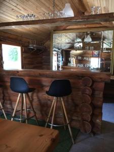 un bar en una cabaña de madera con dos taburetes en Glynns at Club Correze en Meymac