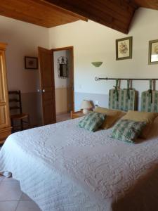 a bedroom with a large white bed with two pillows at Les Cigales in Saint-Andiol