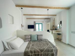 a white bedroom with a bed with pillows at Deco Suites in Naxos Chora