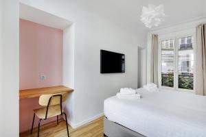 um quarto com uma cama, uma secretária e uma televisão em Pick A Flat's Apartment in Marais/Oberkampf - bvd du Temple em Paris