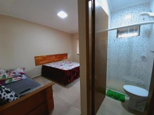 a bedroom with a shower and a bed and a bathroom at Pousada Ilha Sul in Cananéia
