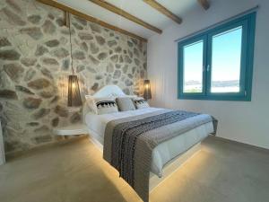 una camera con letto e parete in pietra di Deco Suites a Naxos Chora