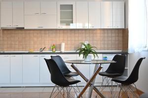 cocina con mesa y sillas negras en New Apartment CRISTAL in the city centre en Novi Sad