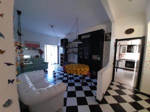 a living room with a white couch and a checkered floor at Appartamento Perla in Beverino