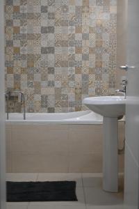 y baño con lavabo y bañera. en New Apartment CRISTAL in the city centre en Novi Sad