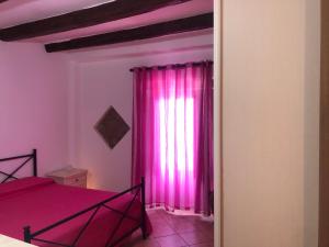 カステル・ディ・トゥーザにあるCasa Jomeryのベッドルーム1室(ベッド1台、ピンクのカーテン付)