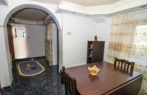 a dining room with a wooden table and an archway at Casa Olanesti in Băile Olăneşti
