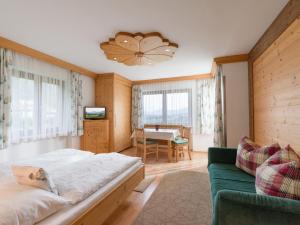 1 dormitorio con cama, sofá y mesa en Gästehaus Anker en Walchsee