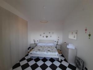 a white room with a bed and a checkered floor at Appartamento Perla in Beverino