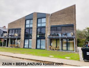 a brick building with tables and chairs in front of it at Ankerix & Deichfix in Büsum