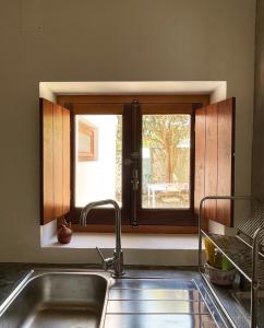 a kitchen with a window over a sink and a sink at São Vicente in Vila Nova de Milfontes
