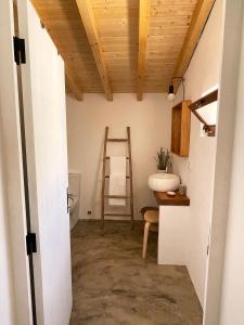 a bathroom with a ladder and a chair in a room at São Vicente in Vila Nova de Milfontes