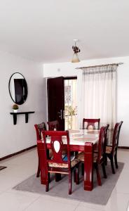 uma sala de jantar com mesa e cadeiras em Furnished Homes Nakuru with pool & GYM em Nakuru