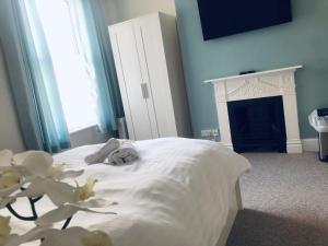 a bedroom with a white bed and a fireplace at Poole Stay in Poole