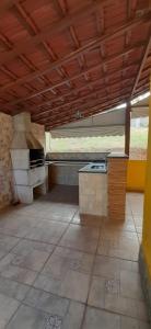 an empty kitchen with a stove in a room at Chalés AABB Valença RJ in Valença