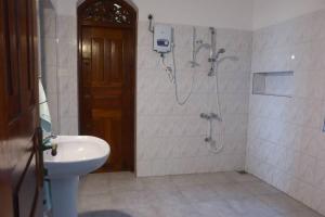 a bathroom with a shower and a toilet and a sink at Villa Sunrise Ferienhaus in Tangalle