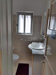 a bathroom with a sink and a toilet and a window at Family Home- Lisboa in Vila Franca de Xira