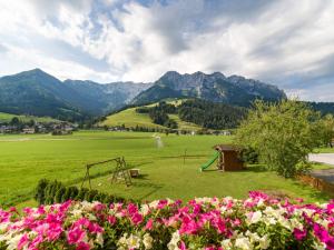 a park with flowers and mountains in the background at Gästehaus Anker in Walchsee