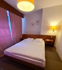 Postel nebo postele na pokoji v ubytování Hôtel de la Poste Martigny - City Center