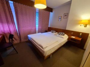 Postel nebo postele na pokoji v ubytování Hôtel de la Poste Martigny - City Center