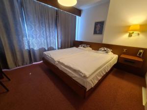 Postel nebo postele na pokoji v ubytování Hôtel de la Poste Martigny - City Center